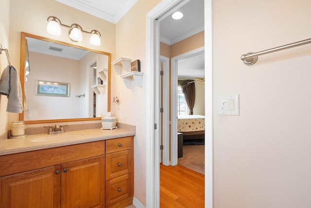 bathroom featuring hardwood / wood-style floors, vanity, and ornamental molding