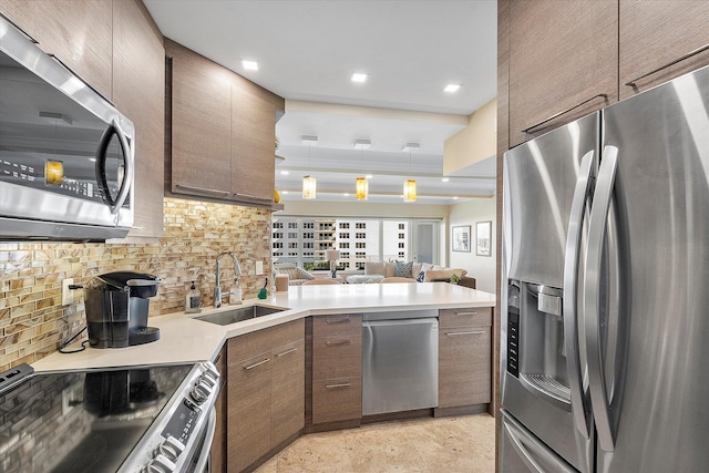 kitchen featuring sink, stainless steel appliances, kitchen peninsula, and tasteful backsplash