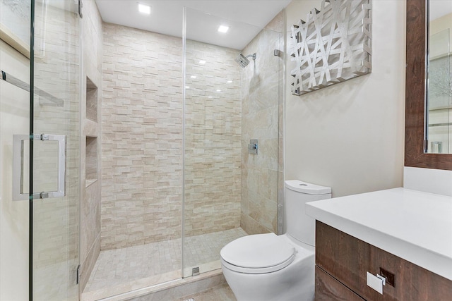 bathroom featuring toilet, an enclosed shower, and vanity