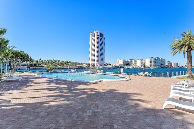 view of swimming pool featuring a patio area and a water view