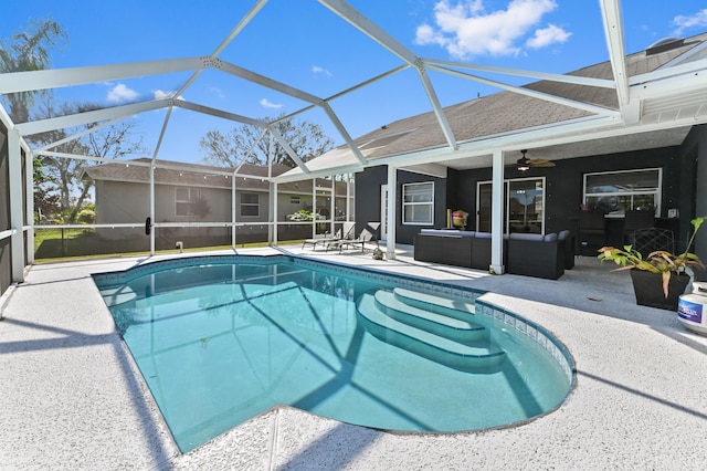 view of pool with a patio area, ceiling fan, glass enclosure, and an outdoor living space