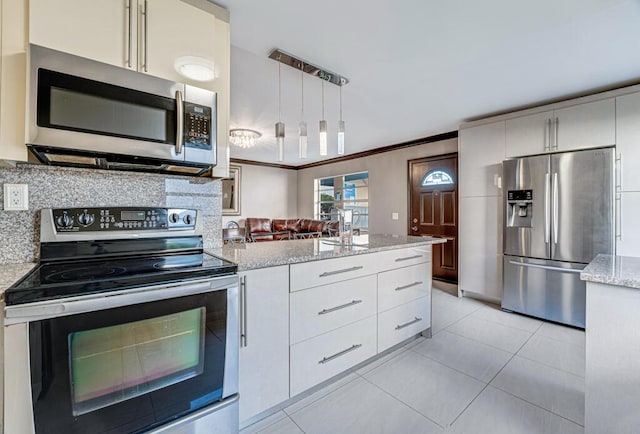 kitchen featuring light stone counters, light tile patterned flooring, pendant lighting, white cabinets, and appliances with stainless steel finishes