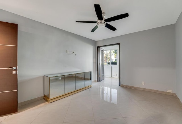 empty room featuring light tile patterned floors and ceiling fan