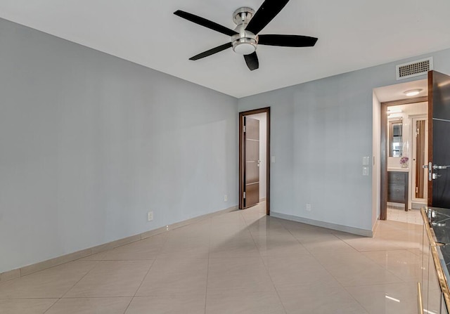 spare room featuring ceiling fan and light tile patterned flooring