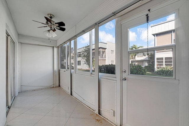 unfurnished sunroom with ceiling fan