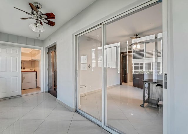 hallway with washer / clothes dryer and light tile patterned flooring