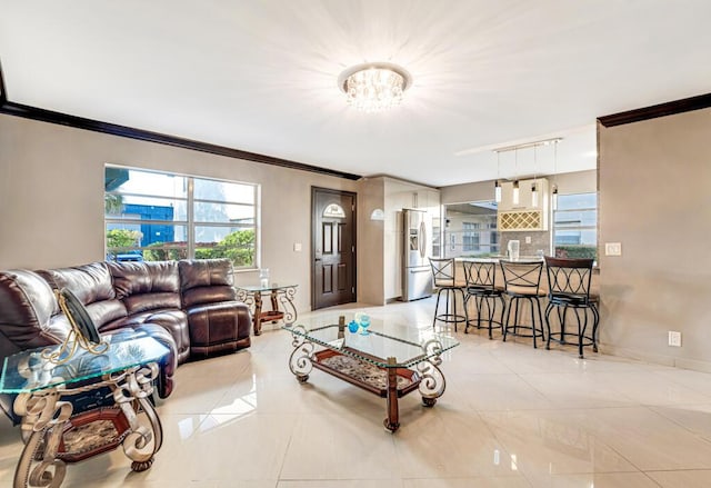 living room with rail lighting, a notable chandelier, light tile patterned floors, and ornamental molding