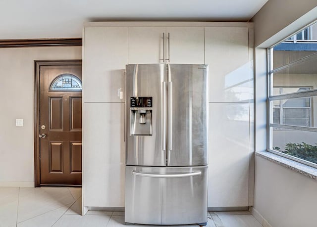 kitchen with stainless steel fridge with ice dispenser, light tile patterned floors, and ornamental molding