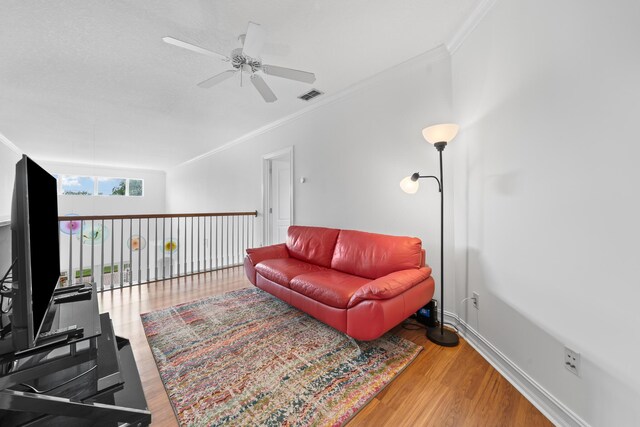 living room featuring hardwood / wood-style flooring, ceiling fan, and crown molding