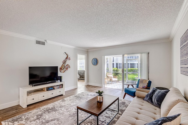 living area featuring a textured ceiling, wood finished floors, ornamental molding, and baseboards