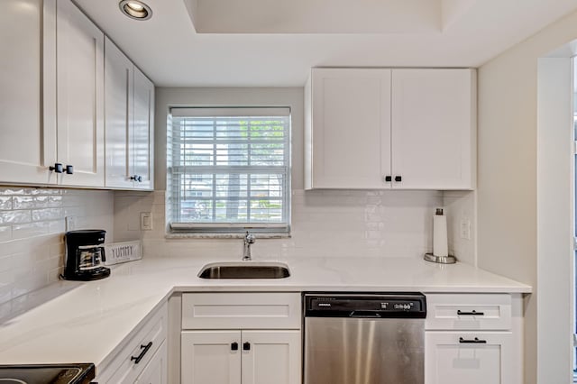kitchen featuring dishwasher, a sink, white cabinets, recessed lighting, and decorative backsplash