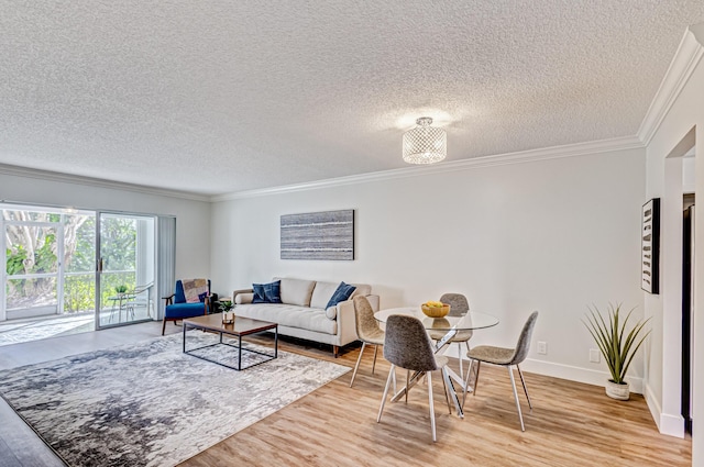 living area featuring light wood-style flooring, crown molding, a textured ceiling, and baseboards