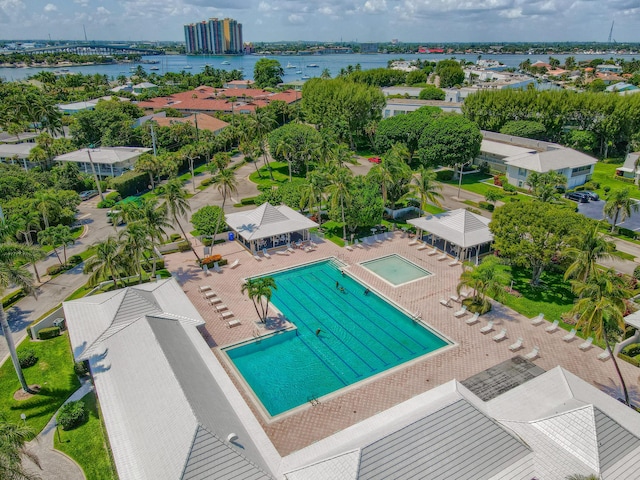 drone / aerial view of a pool and a nearby body of water