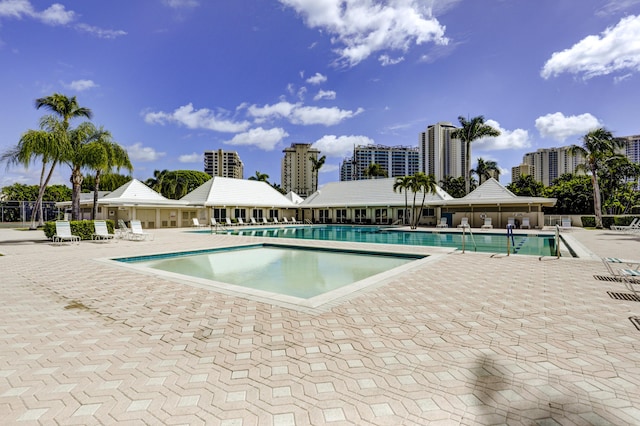 community pool with a patio area and fence