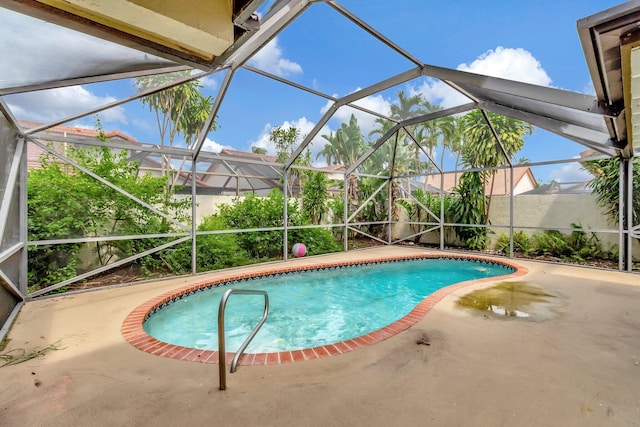 view of pool with glass enclosure and a patio area