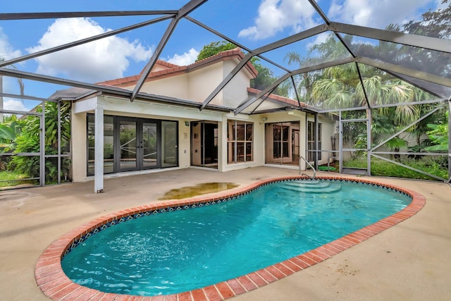 view of swimming pool with glass enclosure, a patio, and french doors