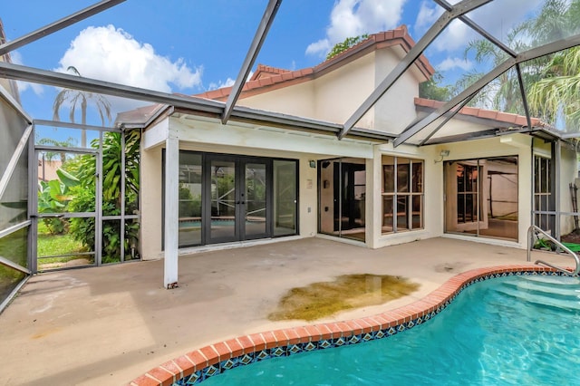 back of house with glass enclosure, a patio, and french doors