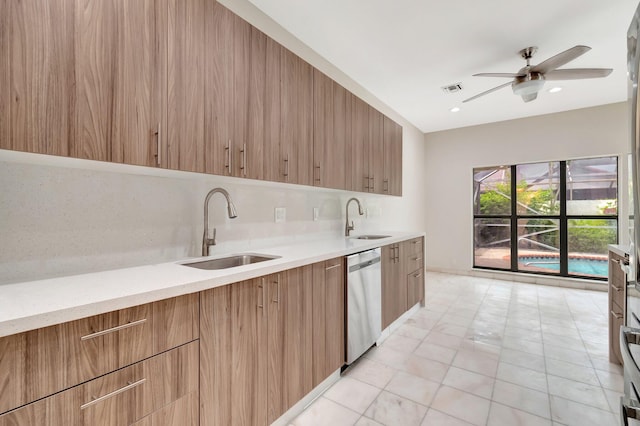 kitchen featuring dishwasher, decorative backsplash, ceiling fan, and sink