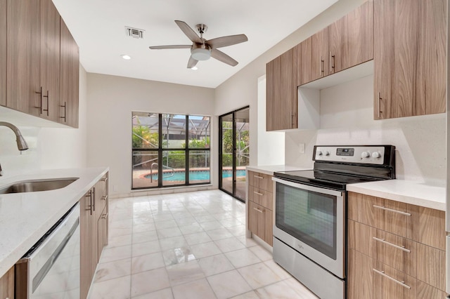 kitchen featuring stainless steel appliances, ceiling fan, and sink