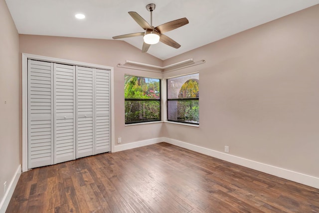 unfurnished bedroom with ceiling fan, dark hardwood / wood-style floors, lofted ceiling, and a closet