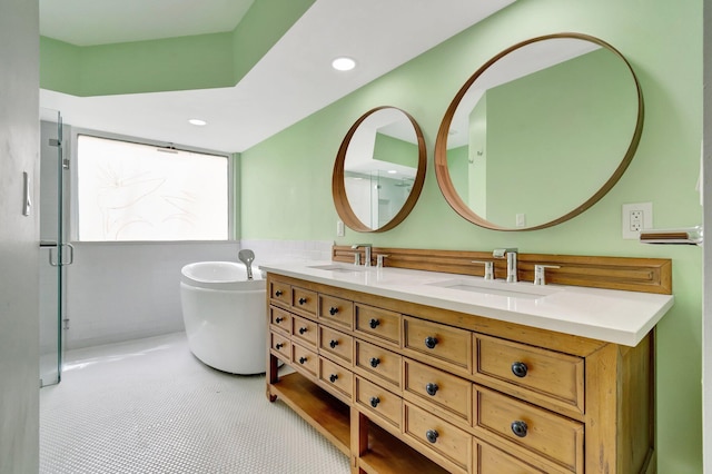 bathroom with tile patterned flooring, a bath, and vanity