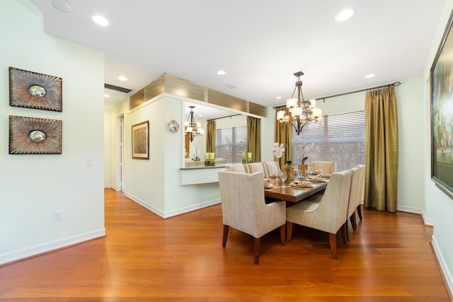 dining area featuring an inviting chandelier, wood-type flooring, and plenty of natural light