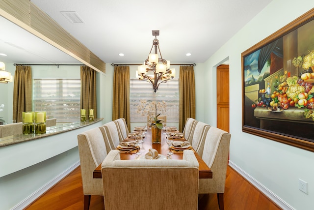 dining room with a notable chandelier and dark wood-type flooring