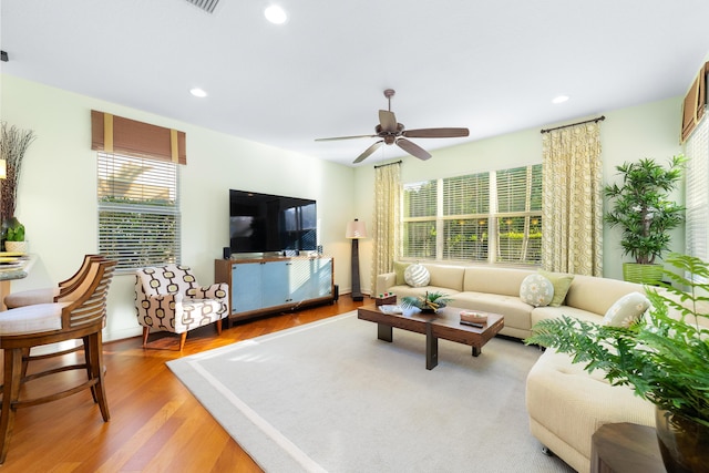 living room with wood-type flooring, a healthy amount of sunlight, and ceiling fan