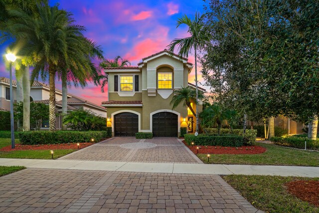 mediterranean / spanish home with a yard and a garage