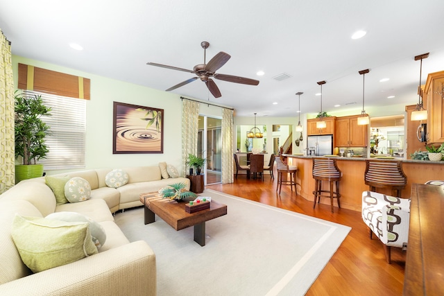 living room featuring light hardwood / wood-style flooring and ceiling fan