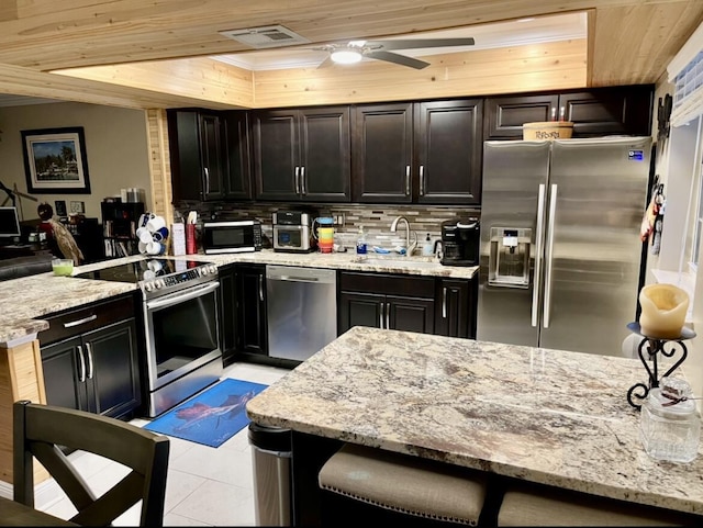 kitchen featuring sink, ceiling fan, light stone countertops, appliances with stainless steel finishes, and wood ceiling