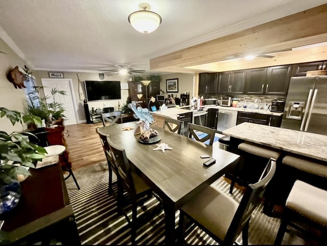 dining space with ceiling fan and light wood-type flooring