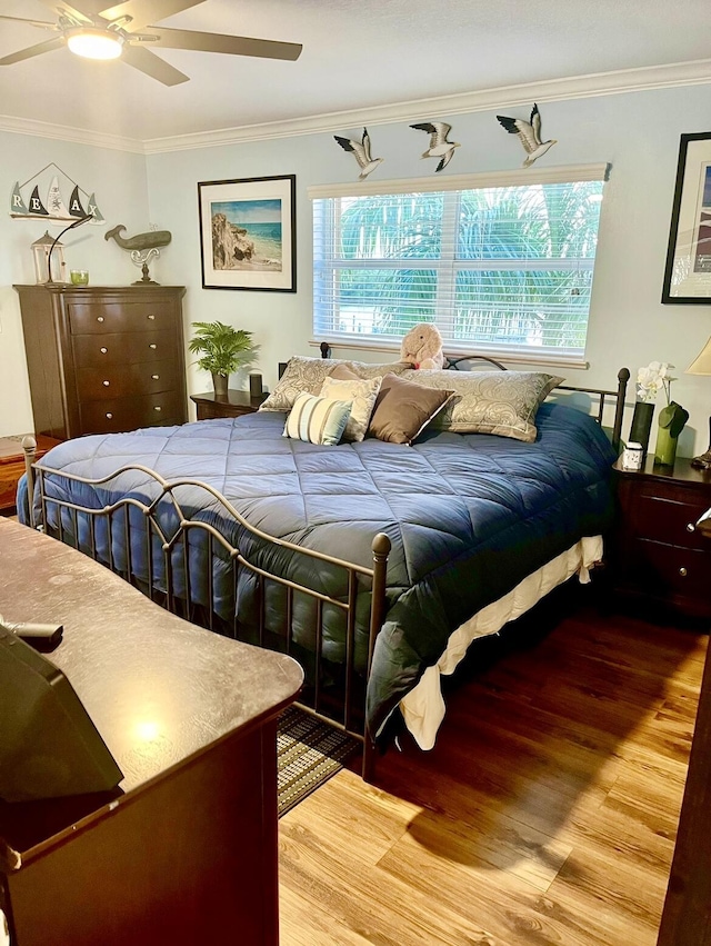 bedroom featuring hardwood / wood-style flooring, ceiling fan, and crown molding