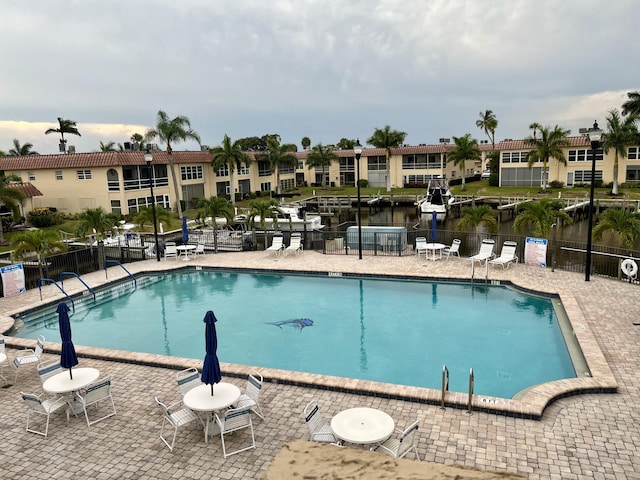 view of pool featuring a patio area and a water view