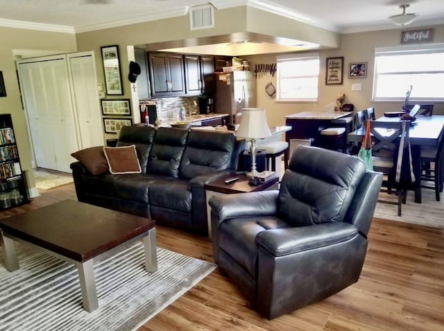 living room featuring light hardwood / wood-style floors and ornamental molding