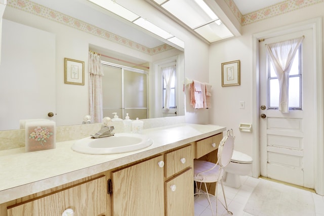 bathroom featuring tile patterned flooring, vanity, toilet, and walk in shower