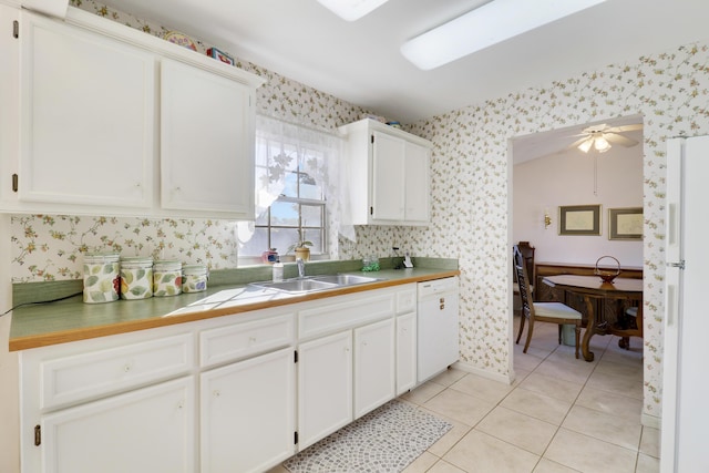 kitchen with white appliances, ceiling fan, sink, light tile patterned floors, and white cabinetry