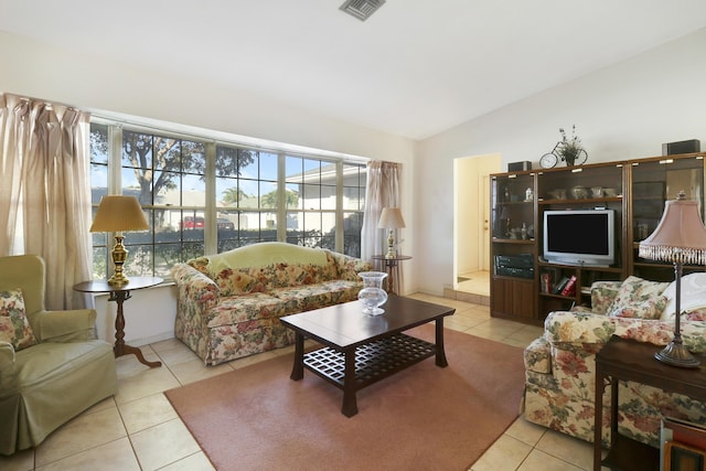 tiled living room featuring a healthy amount of sunlight and lofted ceiling