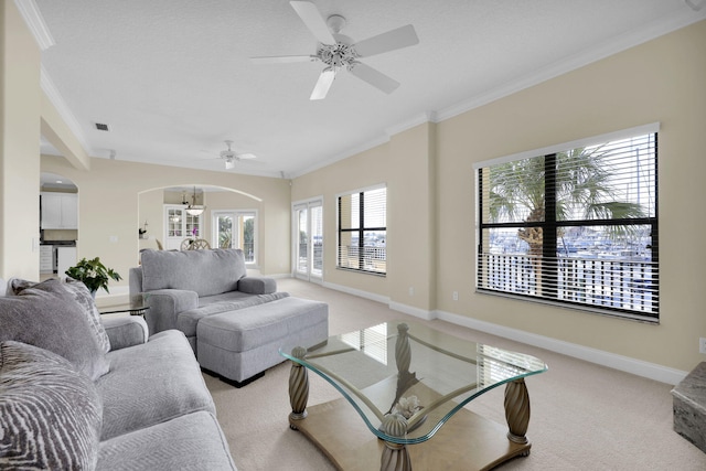 living area featuring light carpet, baseboards, arched walkways, and ornamental molding