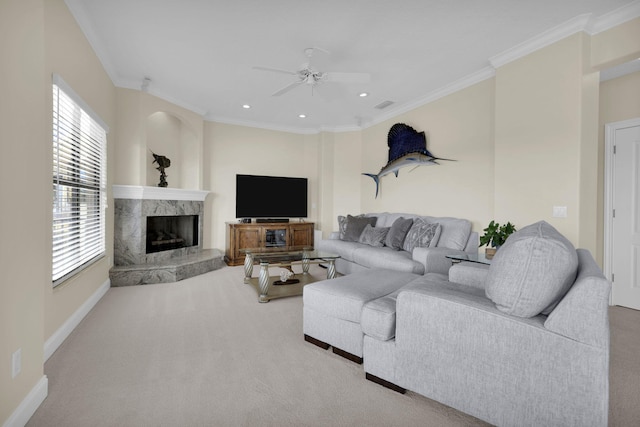 carpeted living room featuring crown molding, a high end fireplace, and ceiling fan