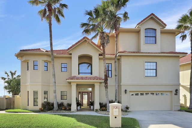 mediterranean / spanish house featuring driveway, a tile roof, an attached garage, and stucco siding