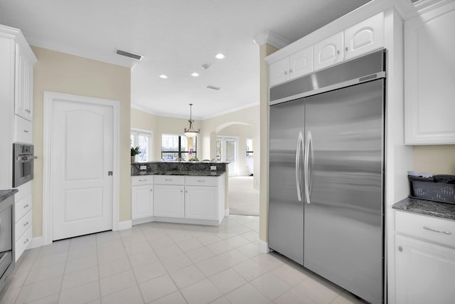 kitchen with arched walkways, crown molding, visible vents, appliances with stainless steel finishes, and white cabinetry