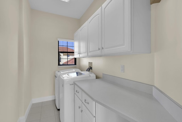 clothes washing area with cabinet space, baseboards, washer and clothes dryer, and light tile patterned flooring