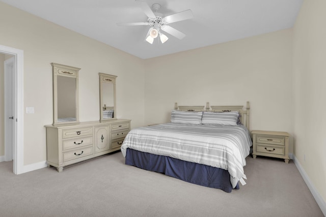 bedroom with light carpet, a ceiling fan, and baseboards