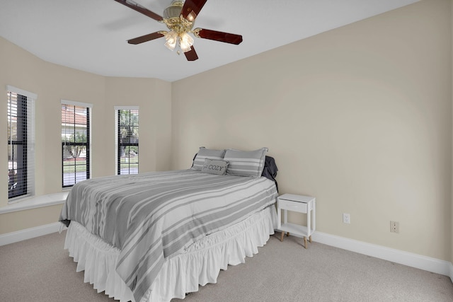 bedroom featuring light colored carpet, ceiling fan, and baseboards