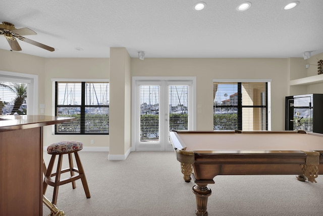 rec room with light carpet, a textured ceiling, a wealth of natural light, and recessed lighting