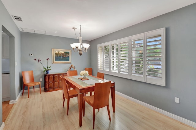 dining area featuring an inviting chandelier and light wood-type flooring