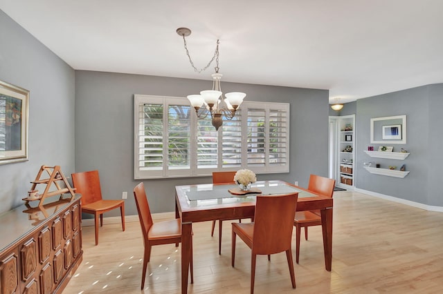 dining area featuring light hardwood / wood-style floors and a chandelier