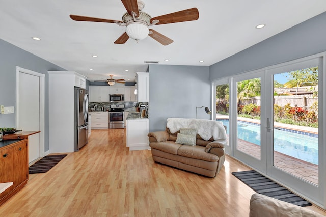 living room featuring ceiling fan and light hardwood / wood-style flooring