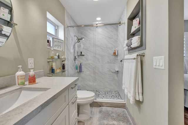 bathroom with toilet, vanity, and a shower with shower door